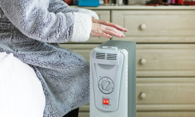 A woman holding her hands above a space heater