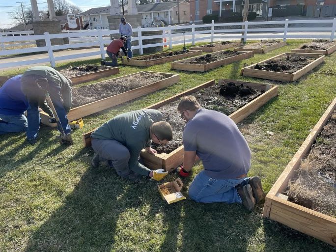 Evergy employees repair raised garden beds in Raytown using recycled electric poles