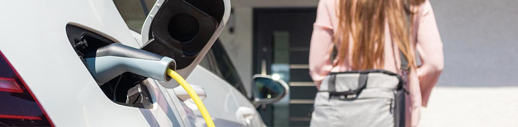 Resident charging car at apartment building after coming home from work